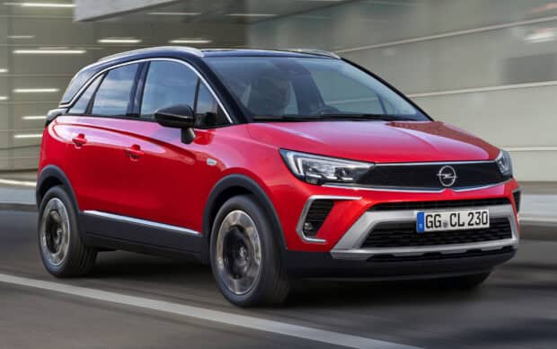 A red Opel Crossland is shown driving past a modern building, HD Desktop Wallpaper