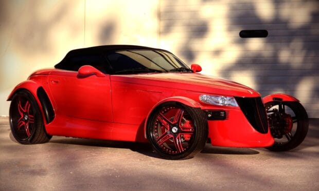 A red Plymouth Prowler with black soft top is parked with shadows on a beige wall, HD Desktop Wallpaper