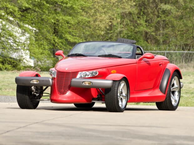 A red Plymouth Prowler is parked outdoors on a clear day surrounded by trees, HD Desktop Wallpaper