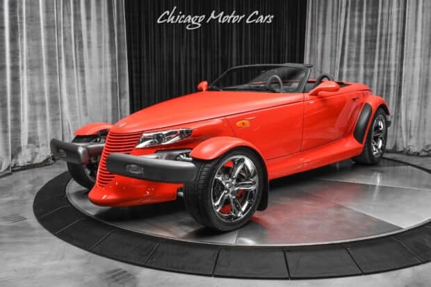 A red Plymouth Prowler is showcased in a modern studio setting with silver curtains, HD Desktop Wallpaper