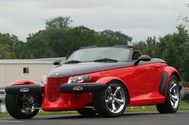A red Plymouth Prowler convertible is parked outside with trees in the background, 2K Desktop Wallpaper