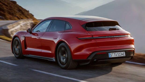 A red Porsche Taycan is driving along a curvy mountain road with a scenic background, HD Desktop Wallpaper