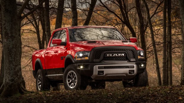 A red Ram pickup is parked in an autumn forest with trees and fallen leaves around, 4K Desktop Wallpaper