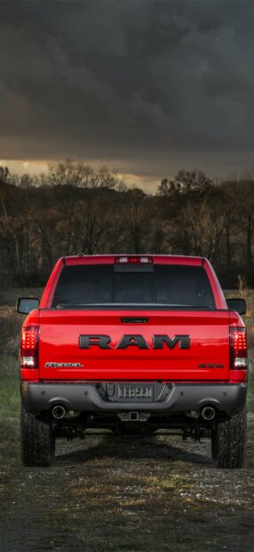 A red Ram truck rebel is parked on a dirt road with a moody sky background, HD Phone Wallpaper