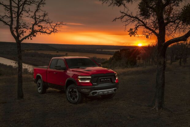 A red Ram pickup is parked in a field during a colorful sunset, 2K Desktop Wallpaper