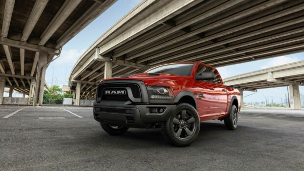 A red Ram pickup truck is parked in an empty urban lot beneath concrete highway overpasses, HD Desktop Wallpaper