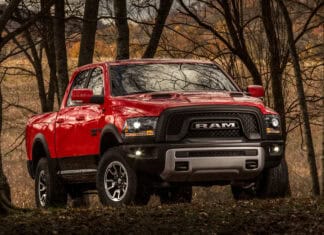 A red Ram truck is parked among tall trees in a forest during autumn, 4K Desktop Wallpaper