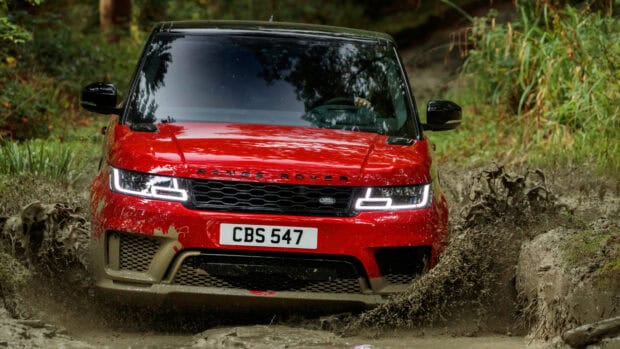 A red Range Rover is splashing mud while off road driving through a forest path, 4K Desktop Wallpaper