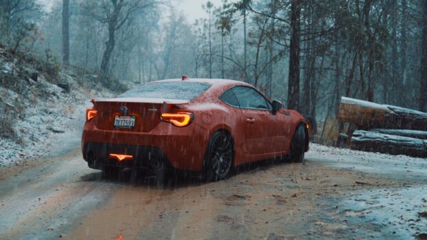 Red Subaru BRZ is covered in snow on a forest trail during winter, 4K Desktop Wallpaper