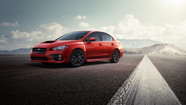 A red Subaru WRX is parked on a deserted road with mountains and clouds in the background, 4K Desktop Wallpaper