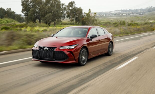 A red Toyota Avalon drives through a scenic area with trees and hills in the background, HD Desktop Wallpaper