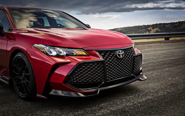 The red Toyota Avalon is parked on a road under a cloudy sky, 2K Desktop Wallpaper