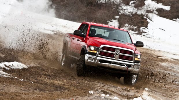 A red truck is drifting on a muddy road with snow around, showing off road driving wallpapers action, 4K Desktop Wallpaper