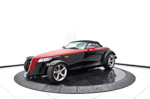A red and black Plymouth Prowler is displayed on a rotating platform in a bright studio, HD Desktop Wallpaper