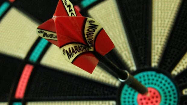 A red dart hitting the bullseye on a classic dartboard in a darts wallpapers scene, HD Desktop Wallpaper