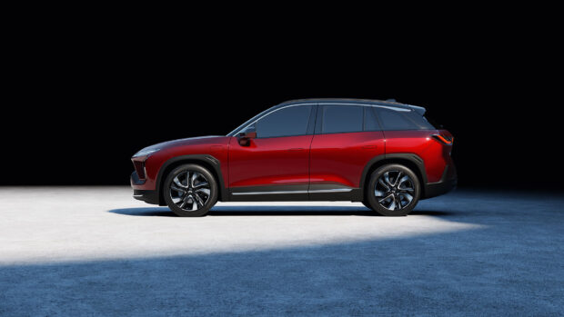 A red Nio electric SUV is parked on a concrete surface with a dark background, HD Desktop Wallpaper