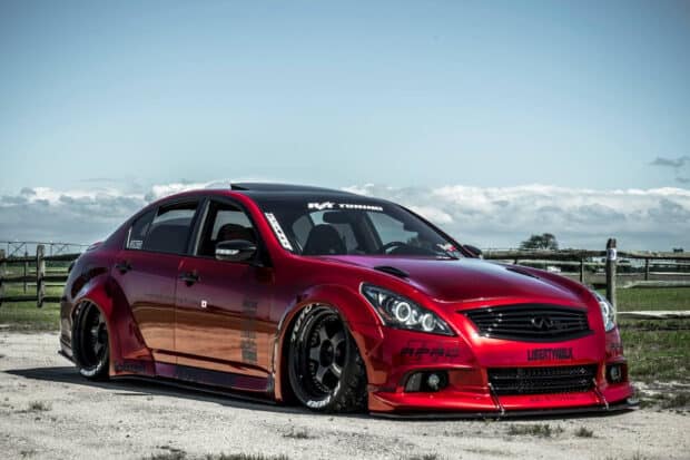A red modified Infiniti G37 is parked on a dirt road near a fence on a clear day, HD Desktop Wallpaper