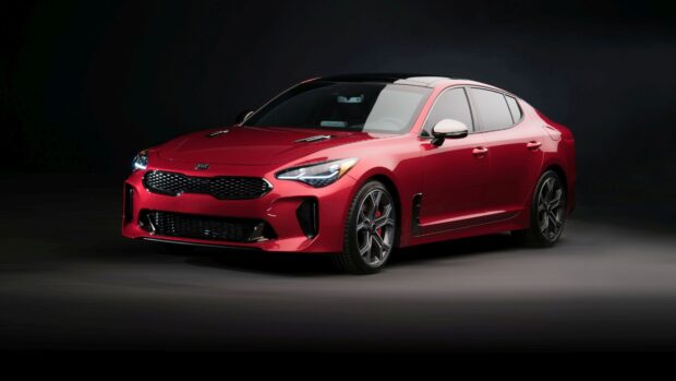 A red Kia car with sleek headlights and alloy wheels is shown, 4K Desktop Wallpaper