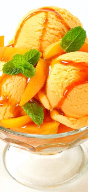 A glass bowl contains apricot ice cream topped with fresh apricot slices and mint leaves, HD Mobile Wallpaper