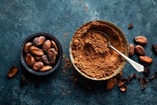 A bowl of cocao powder and cocao beans is placed on a textured blue background for cocao wallpapers, HD Desktop Wallpaper