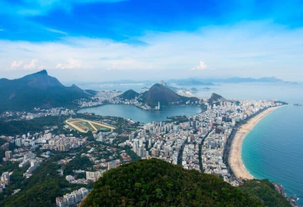 Aerial view of Rio De Janeiro shows city, coastline, and mountains under a clear sky, 2K Desktop Wallpaper
