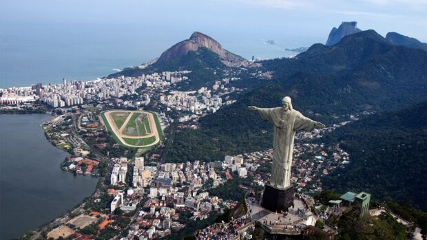 The aerial view captures Rio De Janeiro cityscape with the Christ the Redeemer statue and surrounding mountains, HD Desktop Wallpaper