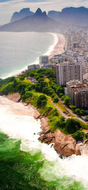 A scenic coastline in Rio De Janeiro shows a beach, city buildings, and mountains in the background, HD Mobile Wallpaper