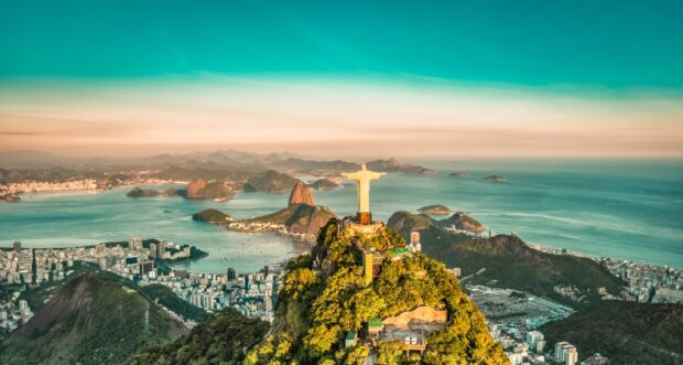 The statue of Christ the Redeemer overlooks the city of Rio de Janeiro with mountains and ocean in the background, 2K Desktop Wallpaper