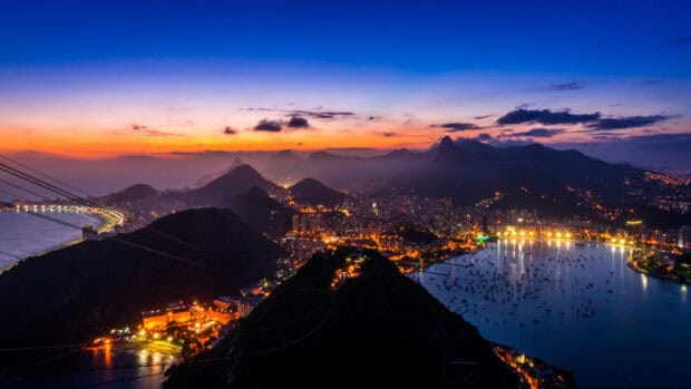 The Rio De Janerio Wallpapers city lights and coastline glow softly under the sunset sky, 4K Desktop Wallpaper