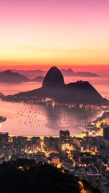 A colorful sunset over Rio De Janerio shows the Sugarloaf Mountain and city lights, 4K Phone Wallpaper