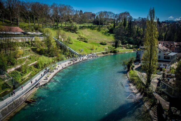 The River Aare in Switzerland flows past green hills and urban areas, HD Desktop Wallpaper