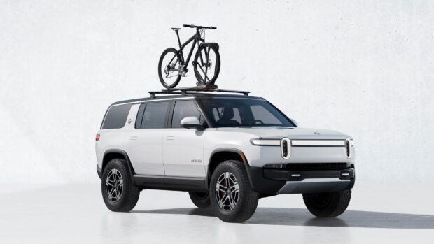 A white Rivian electric SUV with a bicycle mounted on the roof against a plain background, HD Desktop Wallpaper