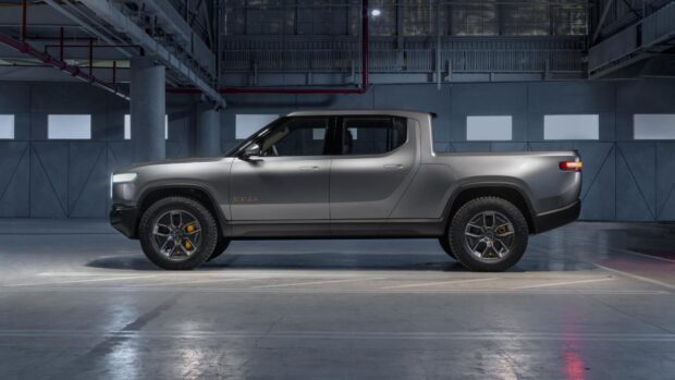 A silver Rivian electric pickup truck is parked in an industrial building, HD Desktop Wallpaper