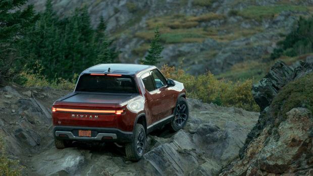 A Rivian vehicle drives over rough mountain rocks on an off road trail, HD Desktop Wallpaper