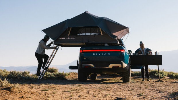 A Rivian truck with camping gear set up outdoors in nature, HD Desktop Wallpaper