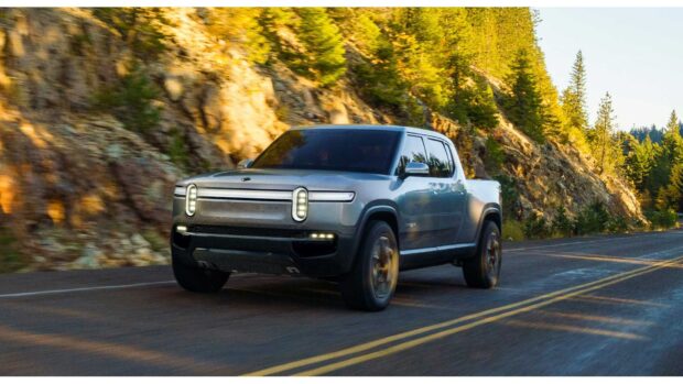 A Rivian Automotive drives along a scenic forest road during daylight, HD Desktop Wallpaper