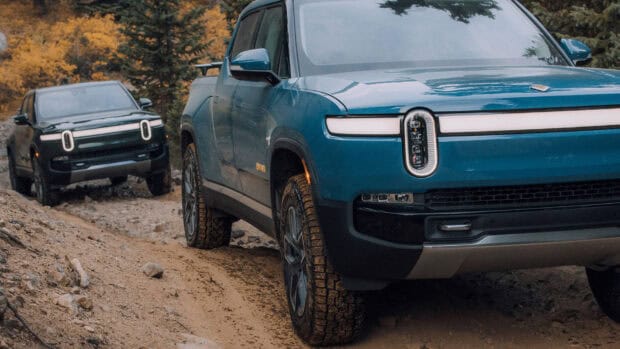 Two Rivian vehicles drive through a forest trail on rough dirt terrain showcasing Rivian Automotive, HD Desktop Wallpaper