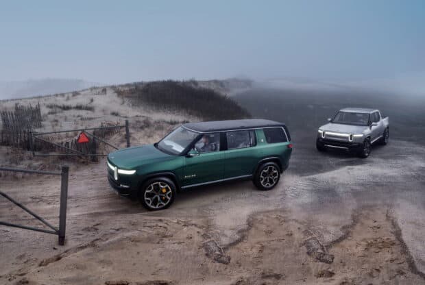 Two Rivian vehicles drive along a misty sandy path near the beach, HD Desktop Wallpaper