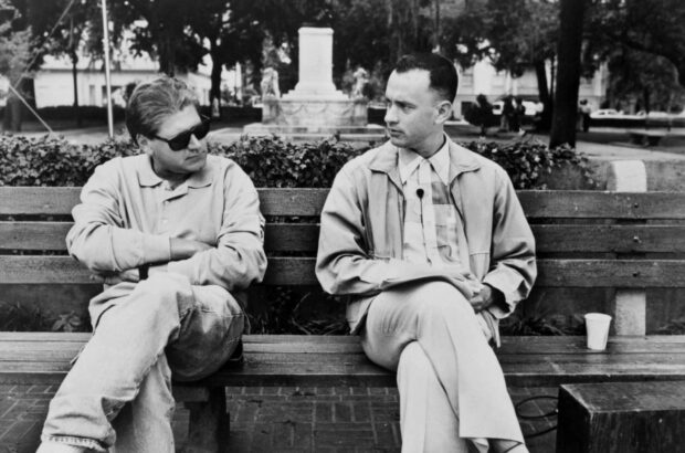 Robert Zemeckis sitting on a bench engaged in a conversation with a man outdoors, HD Desktop Wallpaper