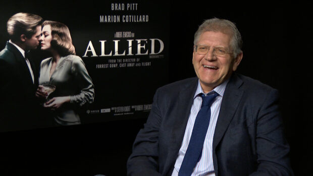 Robert Zemeckis smiles during an interview in front of an Allied movie poster, HD Desktop Wallpaper