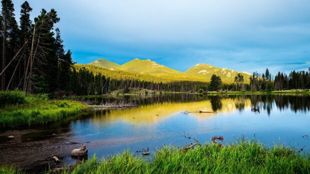 The clear lake reflects the green mountains and sky in Rocky Mountain National Park, 4K Desktop Wallpaper