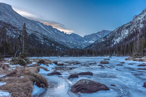 The icy lake and snow covered mountains in Rocky Mountain National Park create a serene winter scene, HD Desktop Wallpaper