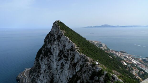 A scenic view of the rocky cliff and coast in Gibraltar with the sea in the background, HD Desktop Wallpaper