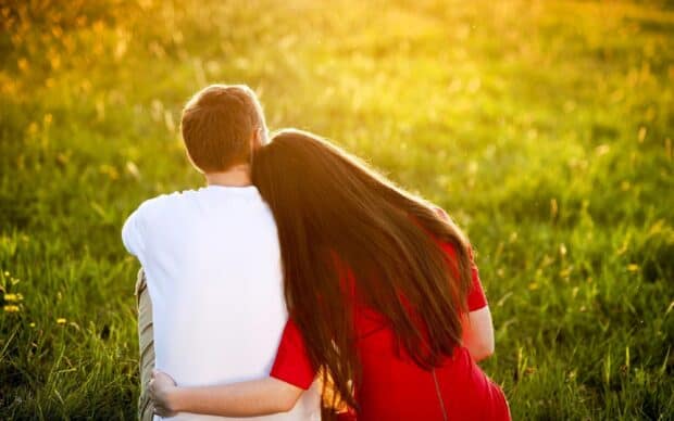 A love couple enjoying a peaceful moment in the sunlit grassy field, 2K Desktop Wallpaper
