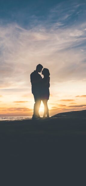 A love couple stands close together by the sea during a beautiful sunset, HD Phone Wallpaper