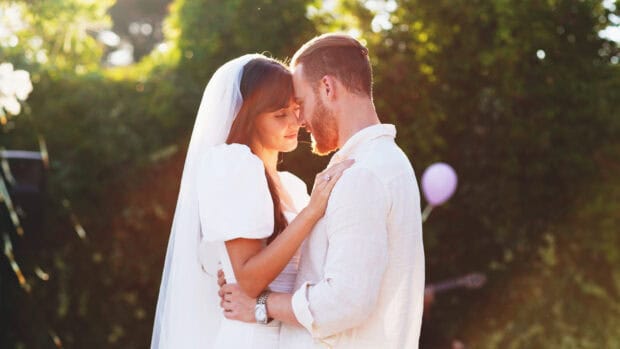 A romantic moment between a couple embracing outdoors with soft sunlight, HD Desktop Wallpaper