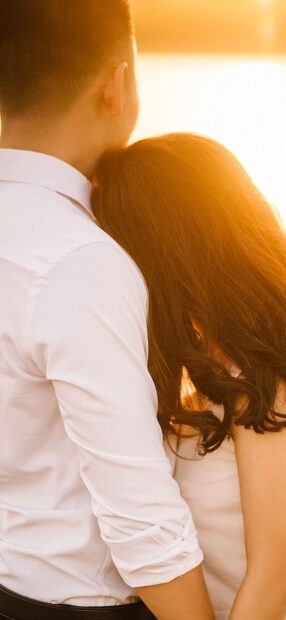 A love couple wallpapers showing a man and woman hugging with warm sunlight behind them, HD Phone Wallpaper
