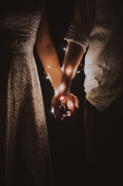 A love couple holding hands wrapped in fairy lights at night, 2K Mobile Wallpaper