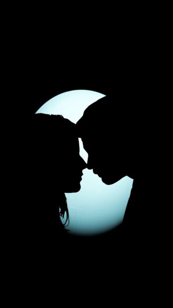A love couple shows a tender moment in silhouette against a glowing full moon, 4K Phone Wallpaper