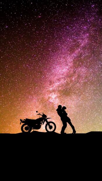 A love couple stands close near a motorcycle with a vibrant night sky full of stars, 2K Mobile Wallpaper
